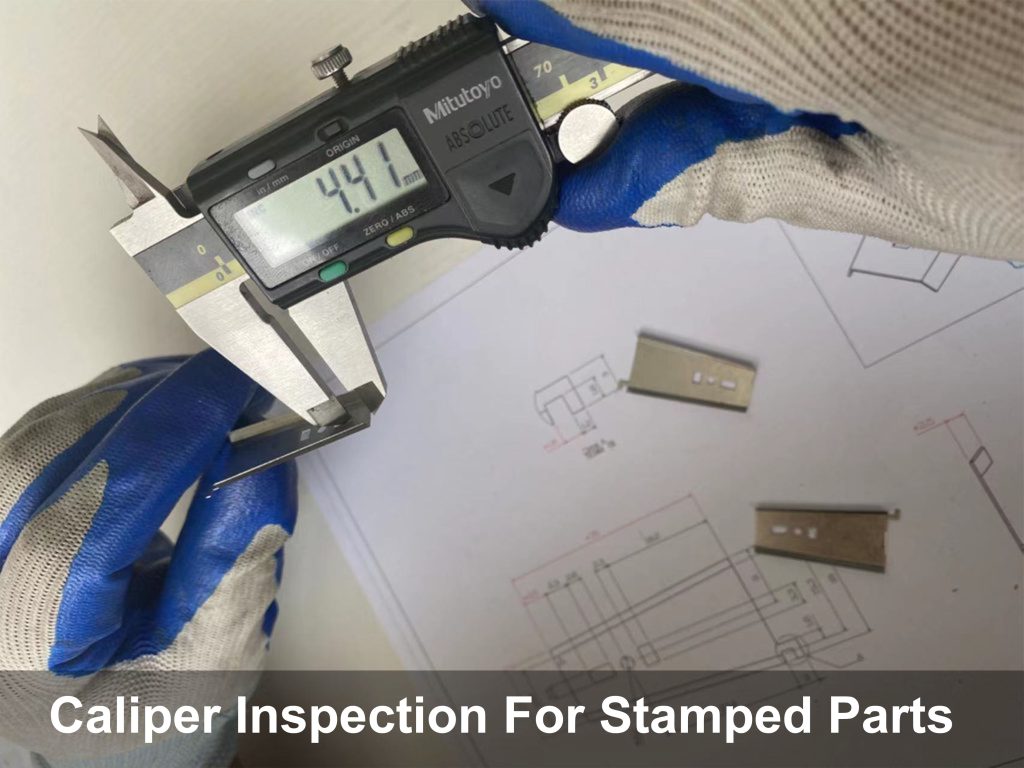 A quality inspector at a stamping workshop in China is taking calipers to measure the dimensions of a stamped shim.