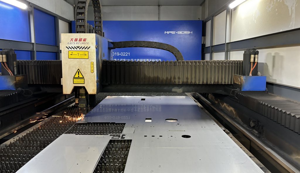 Close-up of a laser cutting machine in action, cutting through sheet metal.